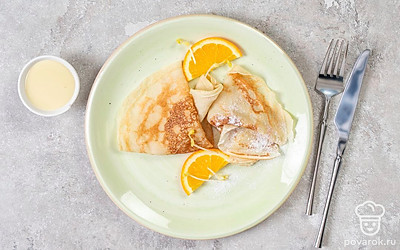 Ароматные блинчики на дрожжах выложите на небольшую тарелку, полейте сгущенкой и подайте к столу вместе с любимой начинкой или топпингом.