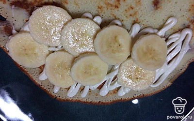 На готовый блинчик уложите взбитые сливки и нарезанный банан. Украсьте по желанию.