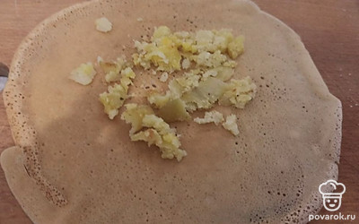 Выложите на блинчик толченый отварной картофель и заверните.