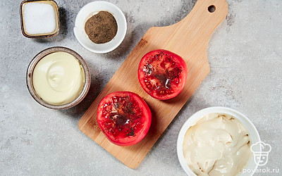 Подготовьте помидоры для фаршировки. Томаты острым ножом разделите на две равные половинки. Мякоть выложите чайной ложкой. Изнутри получившиеся корзинки натрите черным перцем.