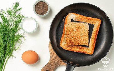 Пожарьте тост. Переверните хлеб на сковороде и разбейте в него яйцо. Закройте крышкой и жарьте до готовности яйца. Желток должен оставаться жидким. Переложите тост на тарелку и посыпьте укропом. Обжаренную сердцевину посыпьте специями и положите рядом с тостом.