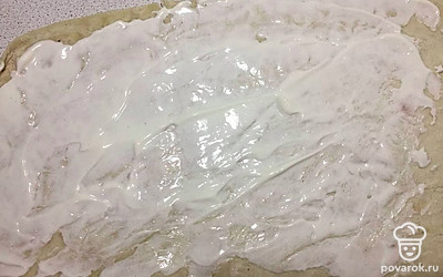 Лист лаваша расстелите на чистой столовой поверхности. Равномерно смажьте лаваш двумя столовыми ложками творожного сыра.