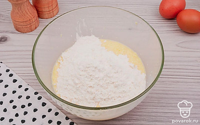 Приготовьте тесто. Для этого в глубокой миске смешайте молоко, растопленное сливочное масло, два яйца, сахар, соль, разрыхлитель и просеянную муку.