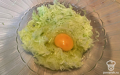 Натрите кабачок на мелкой терке и вбейте одно яйцо.