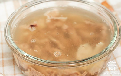 Поставьте холодец застывать. Бульон процедите сначала через дуршлаг, затем через марлю. В форму для холодца выложите сначала морковь, затем мясо и залейте бульоном. Поставьте холодец в холодильник застывать на 4 часа.