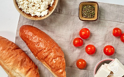 Помидоры черри вымойте, разрежьте на половинки. Багет нарежьте на ломтики толщиной 1 см. Подготовьте блендер.