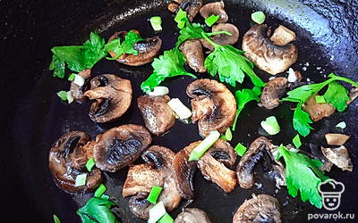 Переверните шампиньоны, добавьте нарезанную зелень.