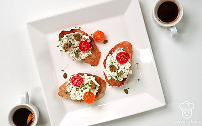 Подавайте тосты с сушеными травами, украсив их половинками черри. Помидоры можно закрепить шпажками для канапе.