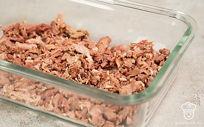 Соберите холодец. По прошествии времени выключите скороварку, достаньте из нее мясо и коренья. Мясо отделите от кости и нарежьте мелкими кусками, бульон процедите через марлю. В форму выложите мясо, залейте бульон, поставьте в холодильник до застывания примерно на 6-8 часов.