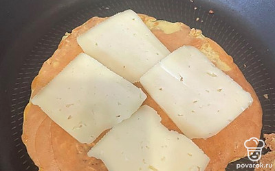 Овсяноблин обжариваем с одной стороны, переворачиваем на другую обжариваться. Сразу выкладываем сыр, чтобы растопился. Держим немного под крышкой.