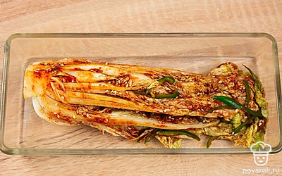 Пекинскую капусту очистите от верхних листьев. Разрежьте на 4 продольные части. Промойте листья капусты, аккуратно раздвиньте, а затем пересыпьте солью каждый лист, особенно у основания. Сложите капусту в глубокую миску и оставьте на четыре часа, периодически поворачивая, чтобы равномерно просолилось. Каждый лист пекинской капусты намажьте подготовленной смесью, уложите капусту в подходящую емкость и оставьте на сутки в тепле, чтобы промариновалась.