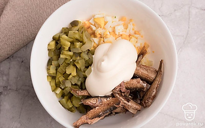 Нарежьте небольшими кубиками соленые огурцы. В подходящую емкость выложите яйца, огрурцы и шпроты. Добавьте майонез, посолите по вкусу и смешайте до однородности.