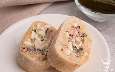 Начините багет полученной смесью и нарежьте на ломтики толщиной около 1 см. Багет фаршированный яйцом, шпротами и соленым огурцом выложите на тарелку и украсьте на свой вкус. Приятного аппетита!