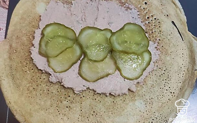 Распределяем паштет по блину, сверху выкладываем колечки огурца.