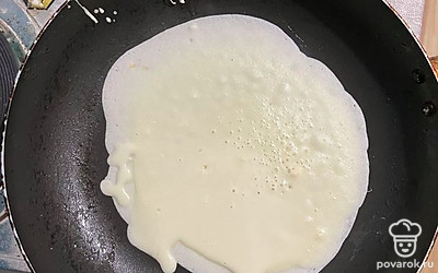 Половником набираем тесто и выливаем, вращая сковородку круговыми движениями. Жарим блин с каждой стороны по 15 секунд.