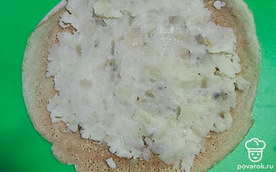 Распределяем картофель по блинчику и сворачиваем рулетом.