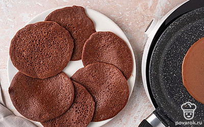 Пеките шоколадный блин с одной стороны 2–3 минуты, пока его поверхность не покроется пузырьками и не перестанет быть липкой. Снимите блин со сковороды на блюдо. Таким же образом испеките блины только с одной стороны из всего теста. Выложите их на блюдо так, чтобы они не соприкасались друг с другом.