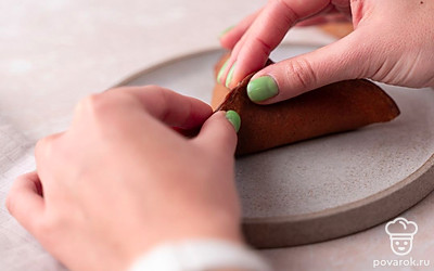 Приподнимите края каждого блинчика с трех сторон и плотно слепите их друг с другом, оставляя небольшое отверстие в середине, чтобы получились объемные треугольники.