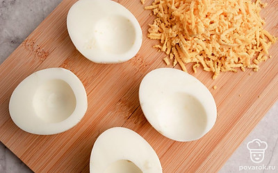 Вареные яйца очистите от скорлупы, разрежьте напополам и извлеките желтки. Натрите желтки на мелкой терке.