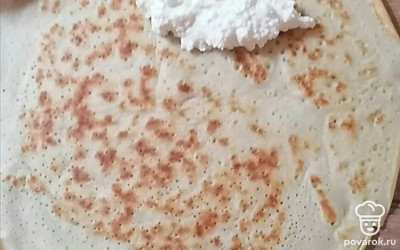 На край блинчика выложите ложку начинки.