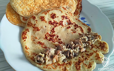 Готовые блины заполните начинкой и сверните рулетиком. 