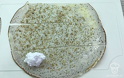 Блин разрежьте на полоски. На каждую выложите по чайной ложке творожной начинки.