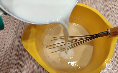 Влейте горячее молоко в тесто. Перемешайте до однородной консистенции.