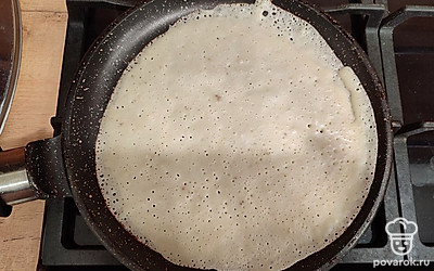 Перед первым блином смажьте сковороду растительным маслом. Порцию теста равномерно распределите по всей поверхности сковороды.