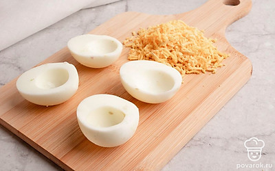 Вареные яйца очистите от скорлупы, разрежьте напополам и извлеките желтки. Натрите желтки на мелкой терке.