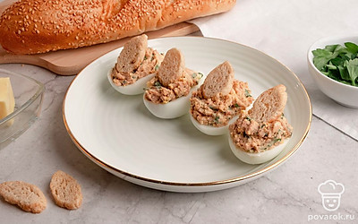 Полученную смесь выложите в готовые половинки яичного белка. Яйца фаршированные яйца паштетом выложите на тарелку и украсьте пшеничными сухариками. Приятного аппетита!