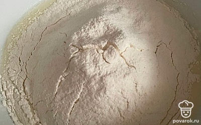 Всыпьте просеянную муку и перемешайте тесто до однородности.