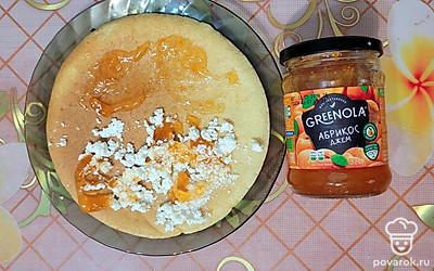 На одну половинку блинчика выложите творог, затем полейте абрикосовым джемом. Накройте второй половинкой блина. 