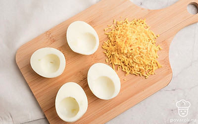Вареные яйца очистите от скорлупы, разрежьте напополам и извлеките желтки. Натрите желтки на мелкой терке.