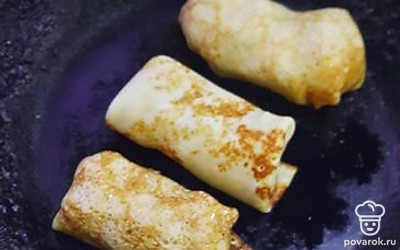 Сверните блины. Выложите их на чугунную сковороду, обжарьте со всех сторон.