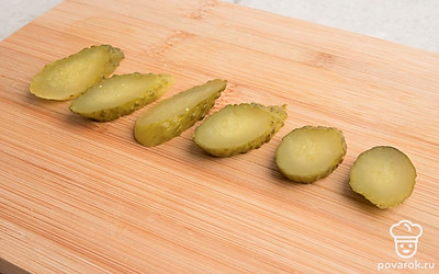 Малосольные огурцы нарезать небольшими кольцами.
