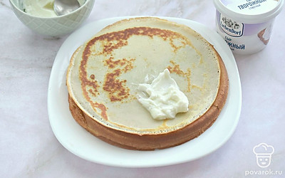 Творожный сыр смешайте с сахарной пудрой. Получившуюся массу выложите на блин (полную чайную ложку с горкой), сверните в виде рулета, треугольника или конверта. 