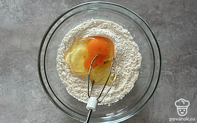 Вбейте яйцо. Затем добавьте 100 миллилитров воды и перемешайте. Так ваше тесто получится без комочков.