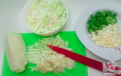 Мелко нарежьте вареные яйца и зеленый лук, отложите в сторону. Мелко нашинкуйте капусту.
