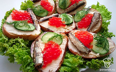 Бутерброды положите на тарелку и украсьте их зеленью.