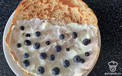 На половину овсяноблина выложить начинку, разложить голубику.