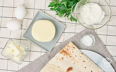 Сливочное масло растопите в кастрюле на слабом огне. Натрите сыр на средней терке. Помойте яйца. Приготовьте форму для выпечки. Зелень петрушки помойте и отделите тонкие веточки от стеблей. Совет: чтобы сыр проще было измельчить на терке, положите его на 10 минут в морозильную камеру.