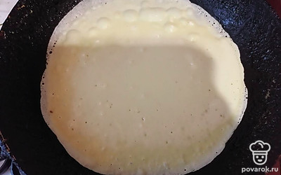 Влить тесто на раскаленную сковороду, смазанную кусочком сала. Жарить блин до румяности с одной стороны, затем перевернуть. 