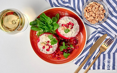 Сервировочную тарелку застелите салатными листьями, на зеленую "подушку" уложите фаршированные кальмарами помидоры.