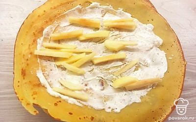 Намажьте блинчики творожным сыром и выложите яблоко.