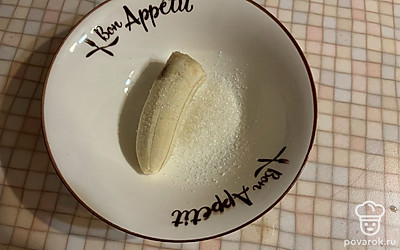 В тарелку поместите банан и сахар. 