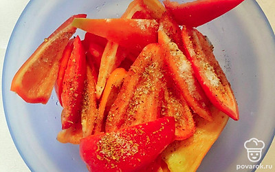 Положите в миску болгарский перец, сбрызните его двумя столовыми ложками оливкового масла, посыпьте солью и раскрошенным перцем, перемешайте.