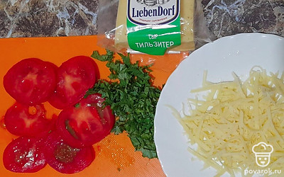Помидор нарежьте кольцами. Зелень измельчите. Сыр натрите на терке.