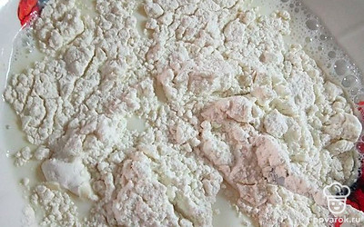 Добавьте теплое молоко и хорошо перемешайте. Порционно добавьте муку. Перемешивайте, пока не получится однородное тесто. Консистенция будет похожа на густой кефир.