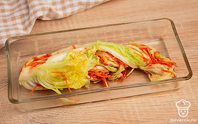 Пекинскую капусту очистите от верхних листьев. Разрежьте на 4 продольные части. Промойте листья капусты, аккуратно раздвиньте, а затем пересыпьте солью каждый лист, особенно у основания. Сложите капусту в глубокую миску и оставьте на четыре часа, периодически поворачивая, чтобы равномерно просолилось. Смешайте с готовой заправкой. Каждый лист пекинской капусты намажьте подготовленной заправкой, уложите капусту в подходящую емкость и оставьте на сутки в тепле, чтобы промариновалась.