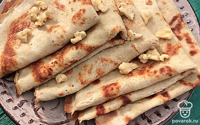 Подавайте блины к чаю с любыми орешками или ягодами.